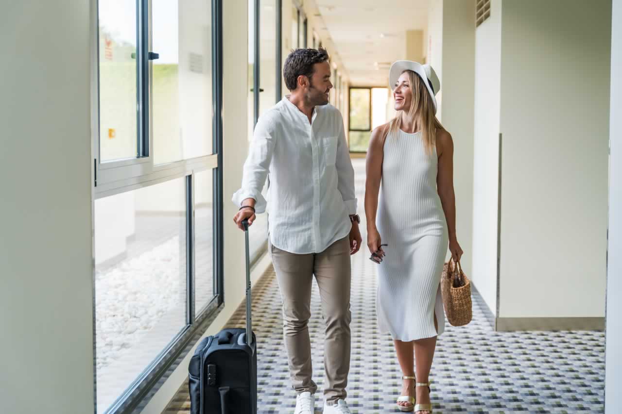 couple-with-luggage-arriving-at-the-hotel-2023-11-28-20-16-56-utc-s Travel Tips for a Seamless Destination Vow Renewal: Managing Logistics and Guest Coordination