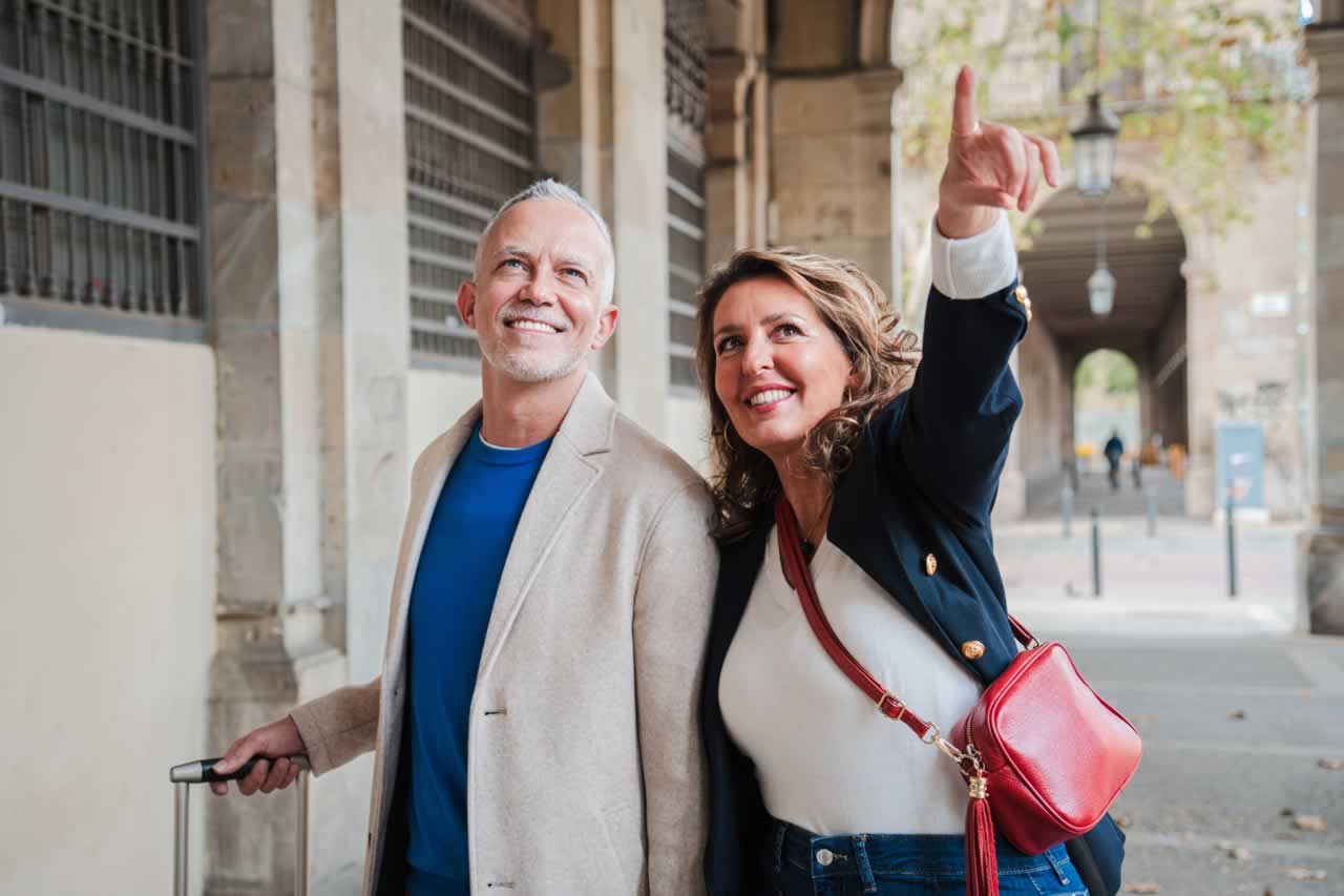 mature-couple-pointing-and-walking-with-a-suitcas-2024-08-30-03-50-32-utc-s Travel Planning for Your Vow Renewal: Essential Tips for Managing International Travel, Accommodations, and Itineraries