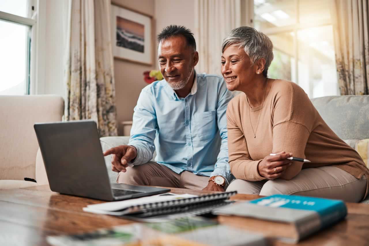 mature-couple-sofa-and-laptop-for-planning-financ-2023-11-27-05-33-46-utc-m How to Plan a Personalized Vow Renewal: A Comprehensive Guide