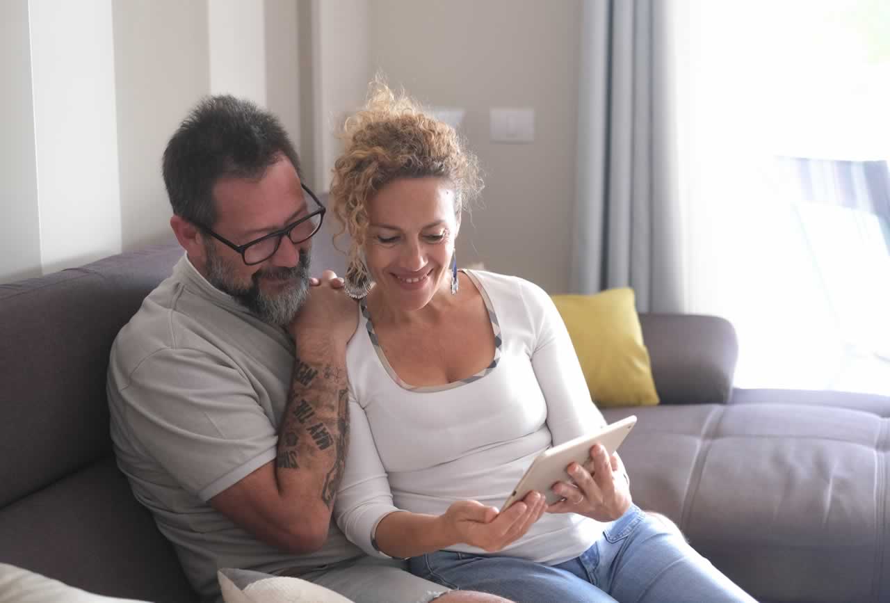 smiling-middle-aged-caucasian-couple-sitting-on-so-2024-07-10-03-58-58-utc-m 12-Month Vow Renewal Planning Checklist: Your Step-by-Step Guide to a Perfect Ceremony